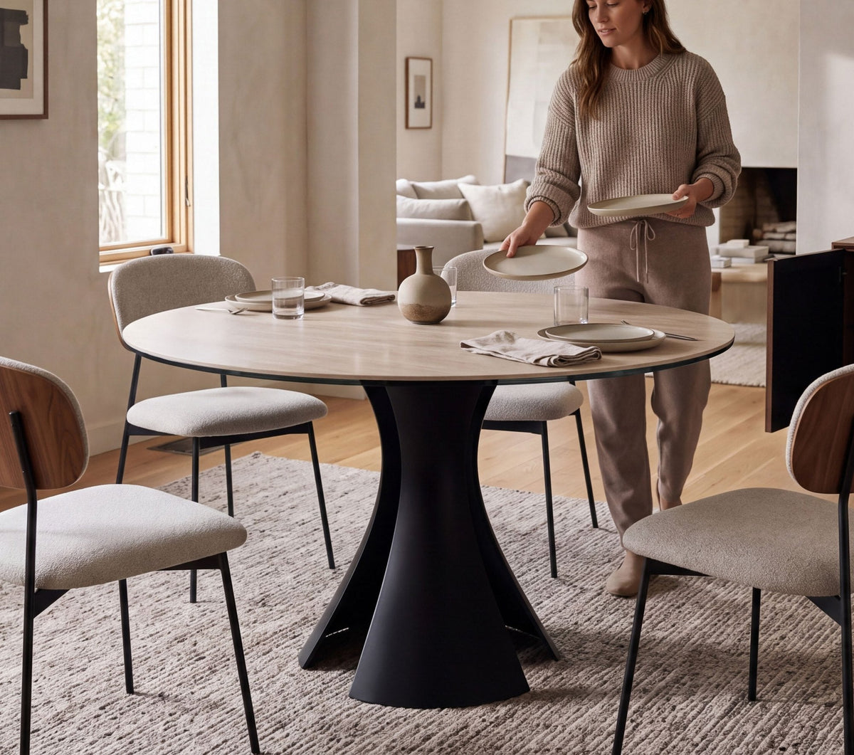 BDI Bloom round dining table with the new Sand Travertine sintered-stone top and Black base, set with Cove dining chairs in Oatmeal with Natural Walnut backs
