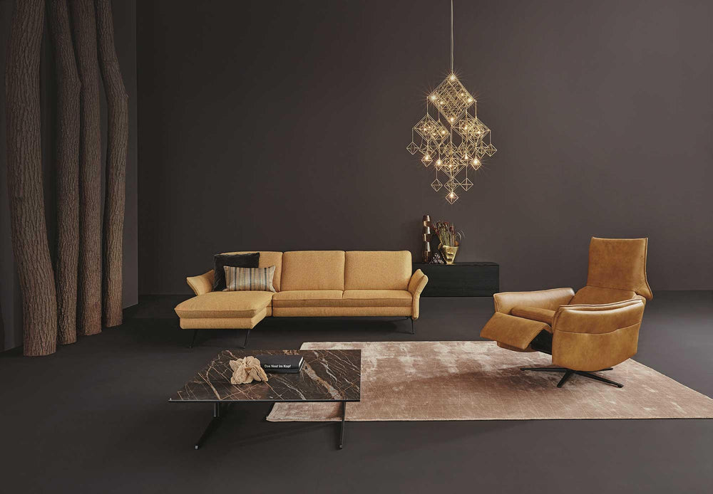 Himolla recliner in cognac leather reclined beside a matching sofa in a modern living room