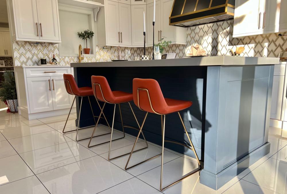 Three Soho Concept Pera stools in burnt orange at a navy kitchen island