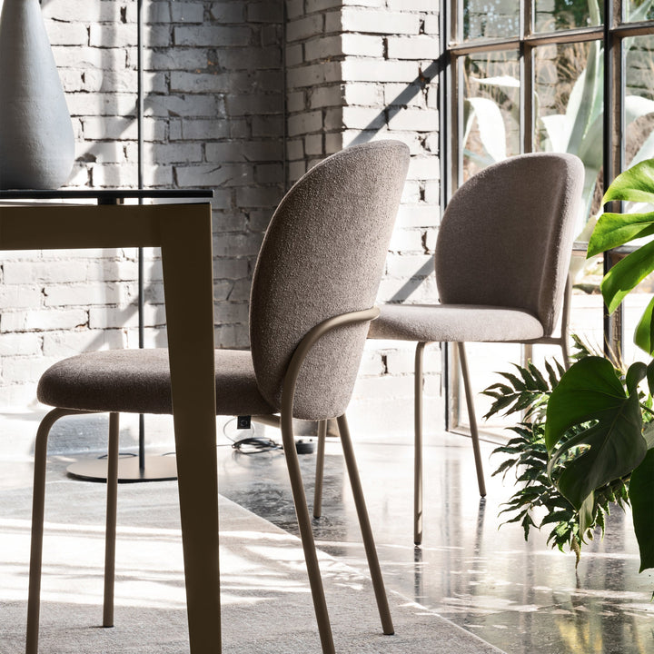 Cozy Mid Dining Chairs in Matte Black with Rain Taupe upholstery in a loft dining room