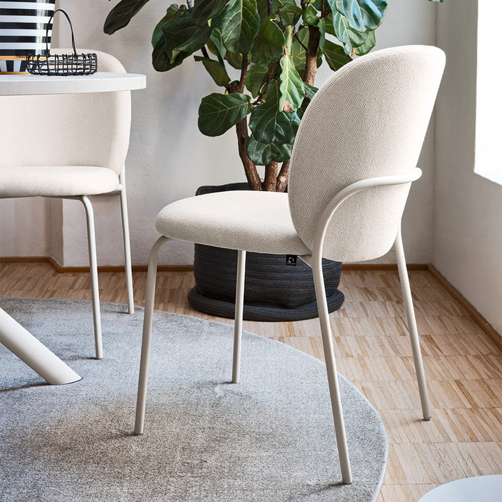 Cozy Mid Dining Chair in Matte Hemp with Cros Sand seat beside a round table