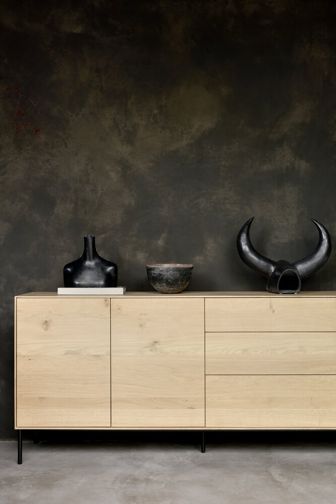 Ethnicraft wood sideboard against a dark textured wall