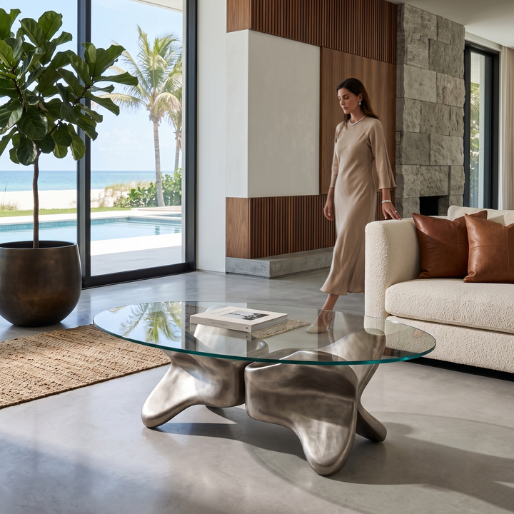 Arditi Psyche sculptural glass coffee table beside a cream sofa in an ocean-view living room