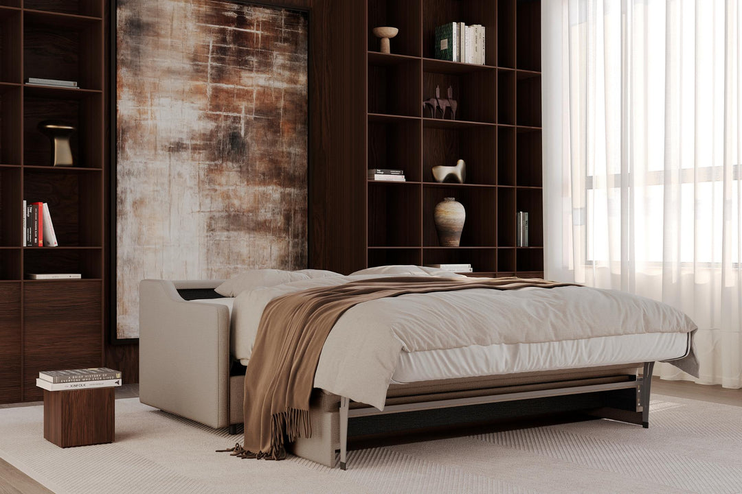 Carnell sleeper sofa partly opened into a bed with a throw in a library-style room