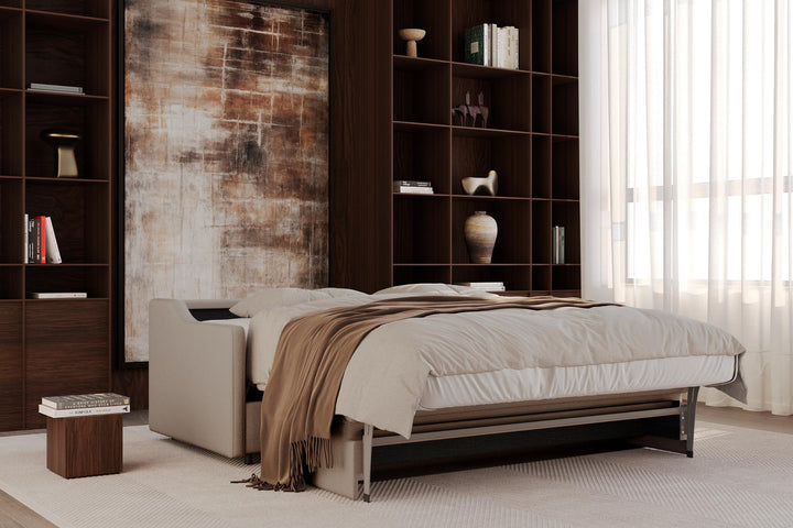 Carnell sleeper sofa partly opened into a bed with a throw in a library-style room