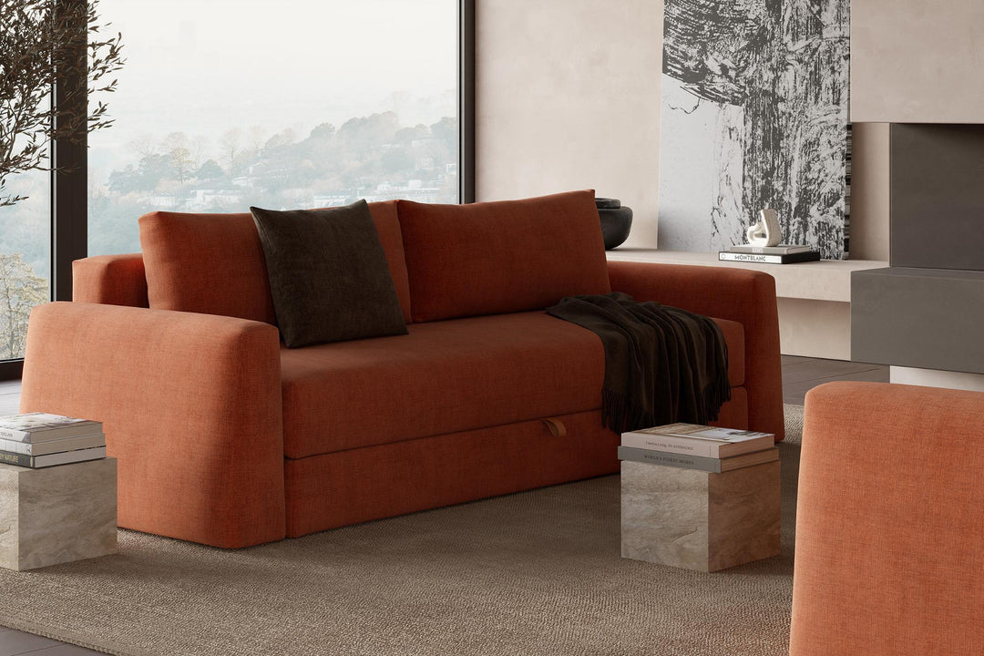 Rust Cone sleeper sofa with pillows in a room with city views