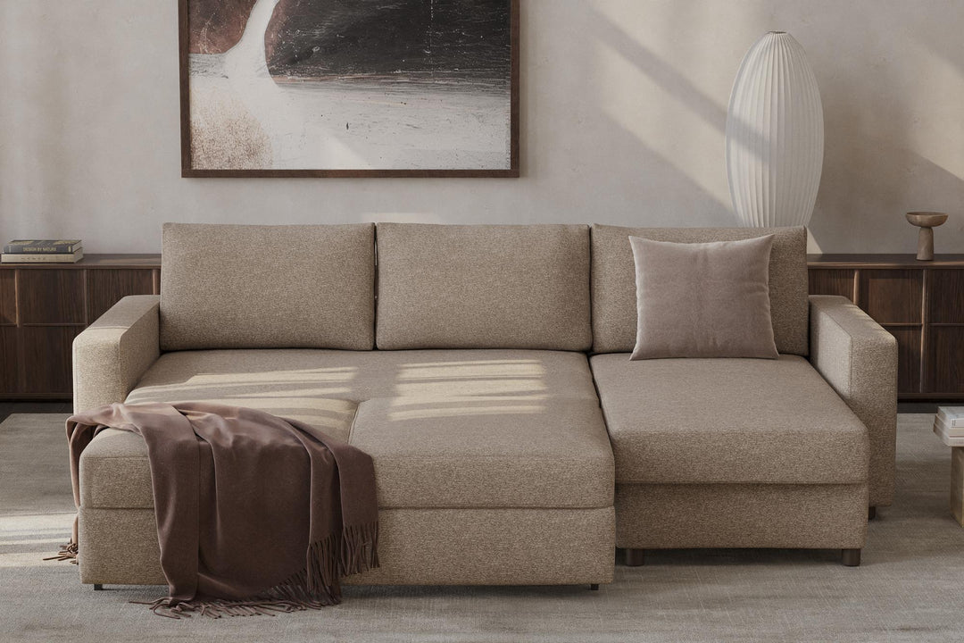 Beige Neah sleeper chaise sectional opened into a bed with a throw