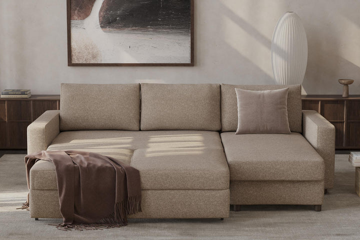 Beige Neah sleeper chaise sectional opened into a bed with a throw