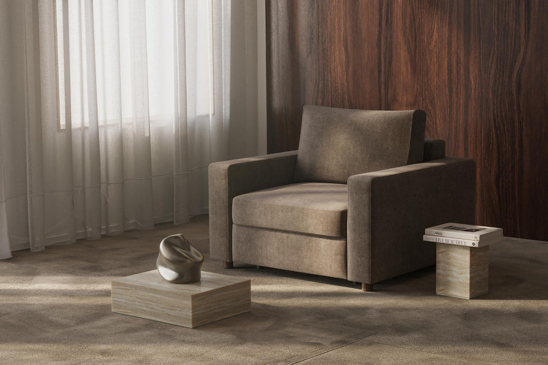Taupe Neah sleeper chair with standard arms beside a side table in a wood-paneled room
