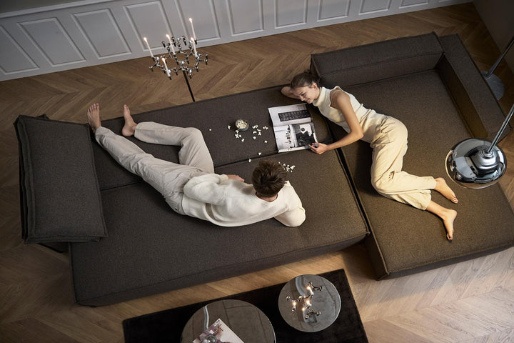 Two people relaxing on a dark gray Newilla chaise sectional bed seen from above