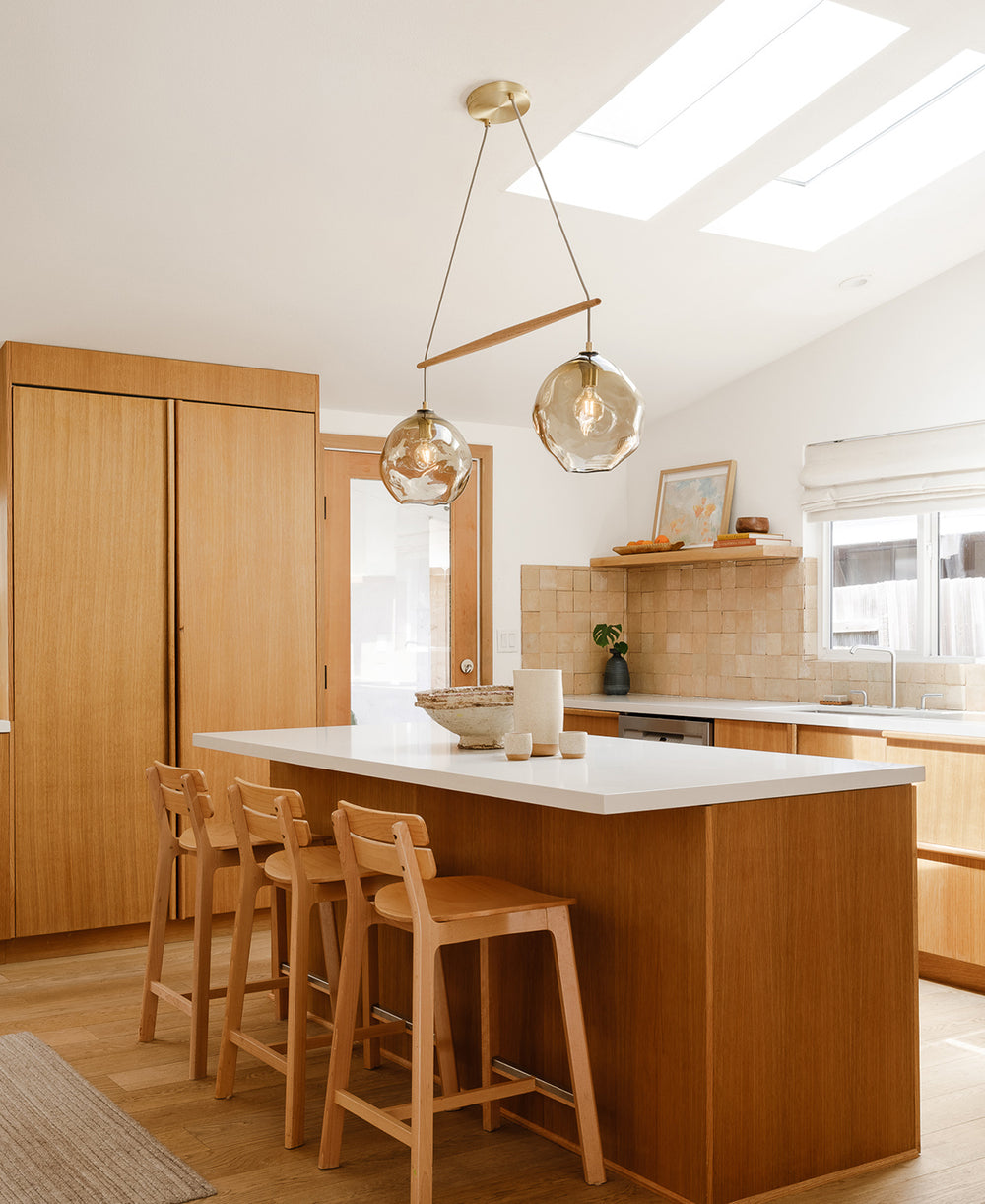 Cerno Linea Selva chandelier installed above a warm modern kitchen island
