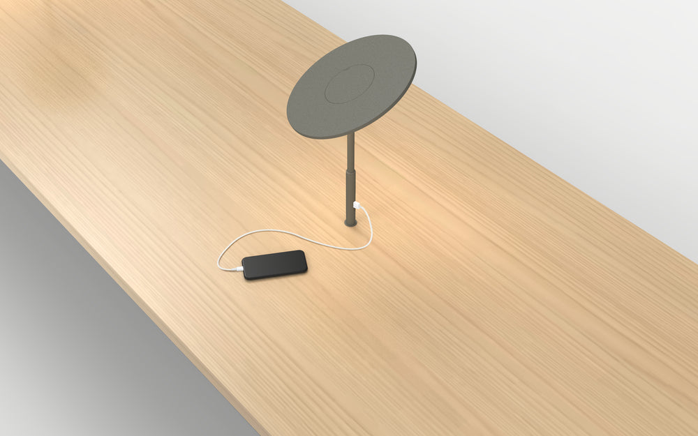 Circa Grommet Table Lamp by Pablo Designs on a wood desk with integrated phone charging