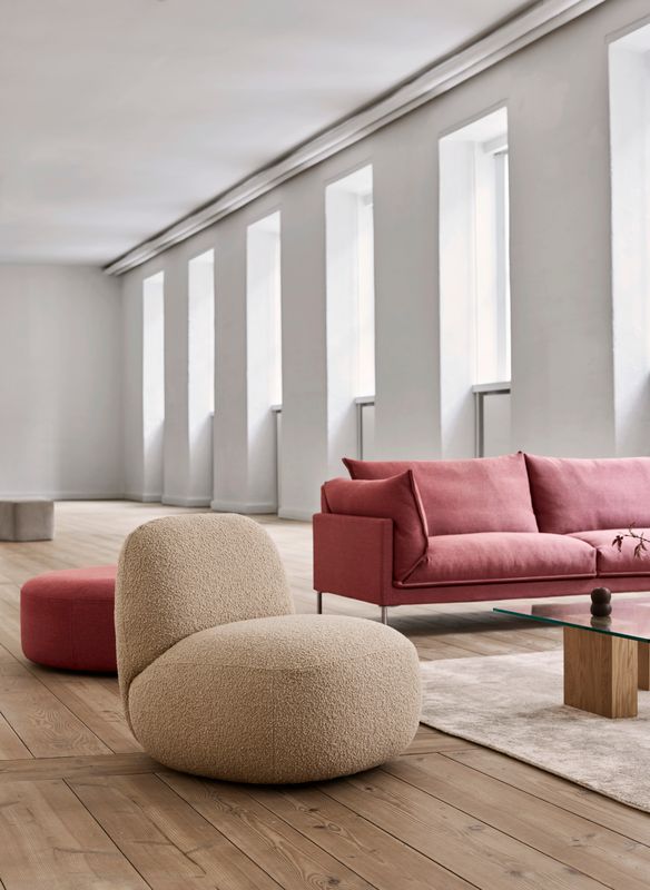 Eilersen Havana Curl 06 lifestyle — Butterfly sofa 240x90 cm Sack 02 ENVIR CLOSE UP 1 with Havana chair without arm Curl 06 Wheel footstool Bun footstool Puzz table and Stick carpet Sand 4984
