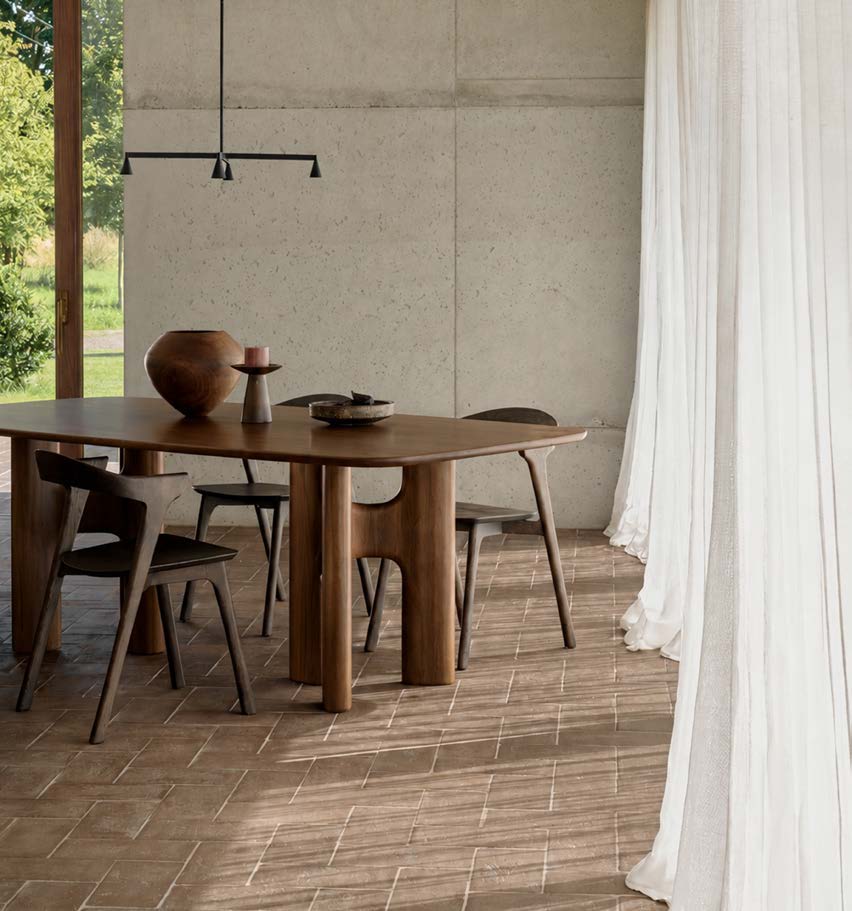 Ethnicraft Flow teak wild brown dining table in a modern dining room