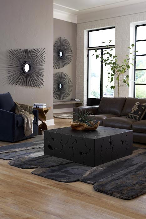 Phillips Collection black square Teak Slice coffee table beside a blue chair and a gray sofa