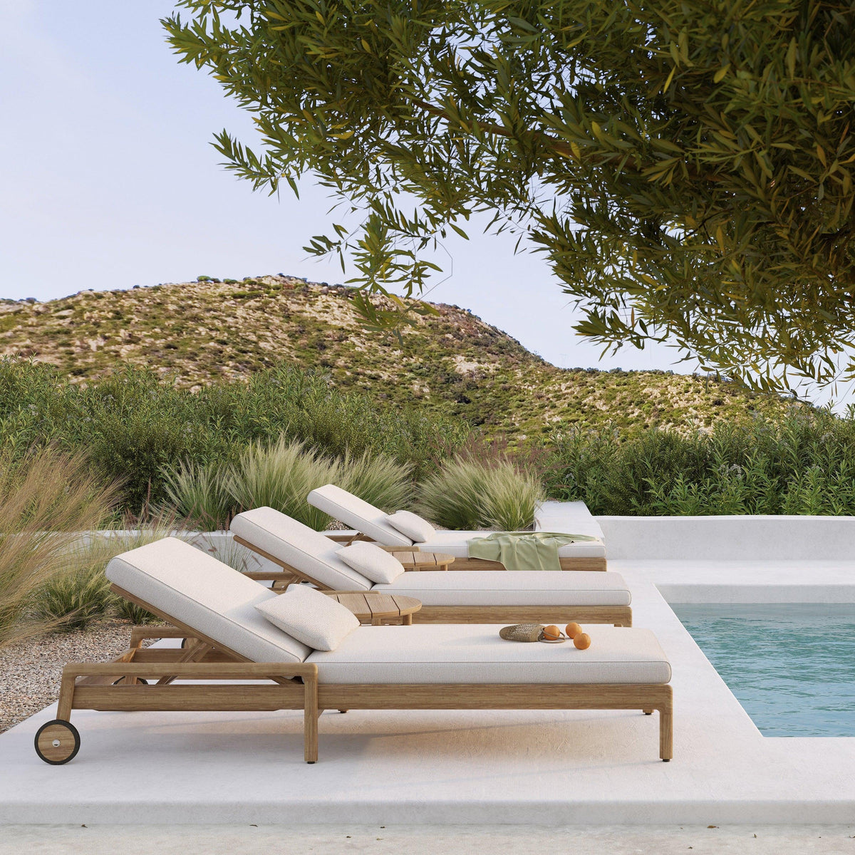 Ethnicraft Jack outdoor loungers beside a pool