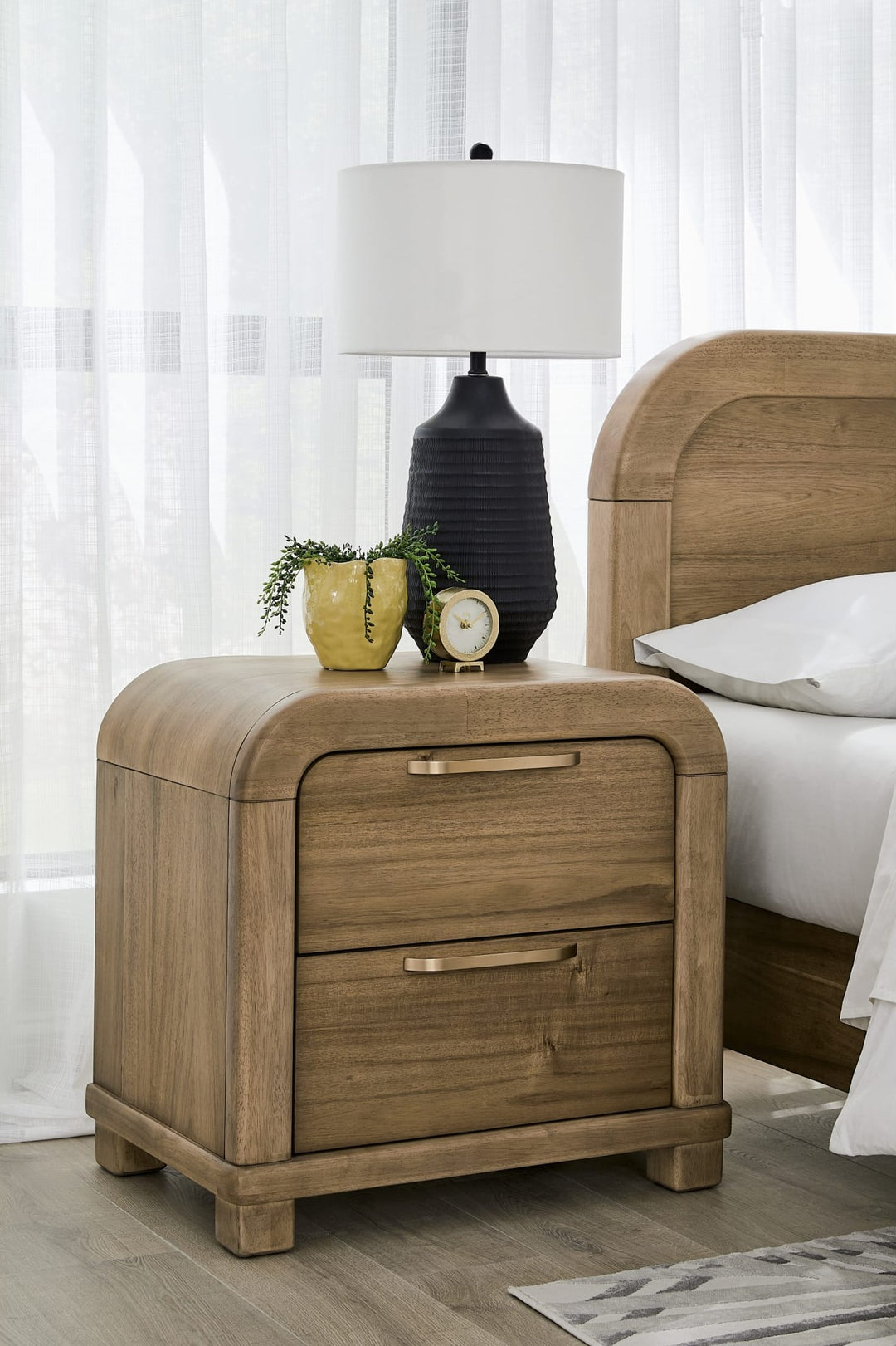 Kione Two Drawer Nightstand in Lioness — in a bedroom setting