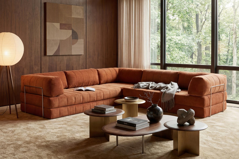 CozyPad Sleeper Sofa Corner with arms by Innovation Living in rust orange velvet with round wood coffee tables in a wood-panelled room with forest views