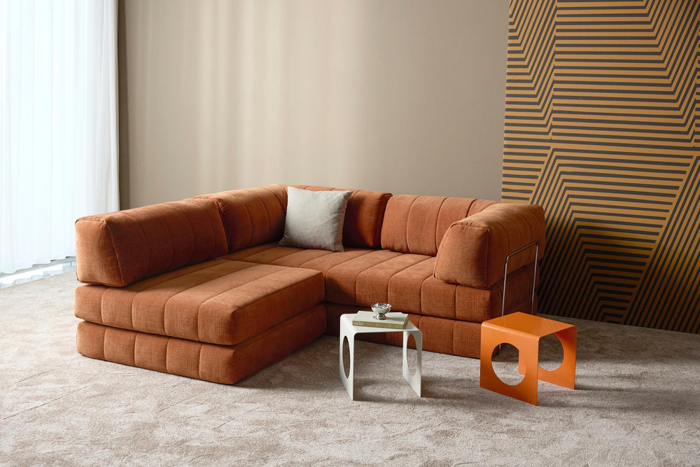 CozyPad Chair by Innovation Living in rust orange velvet with white and orange side tables by a striped wood wall