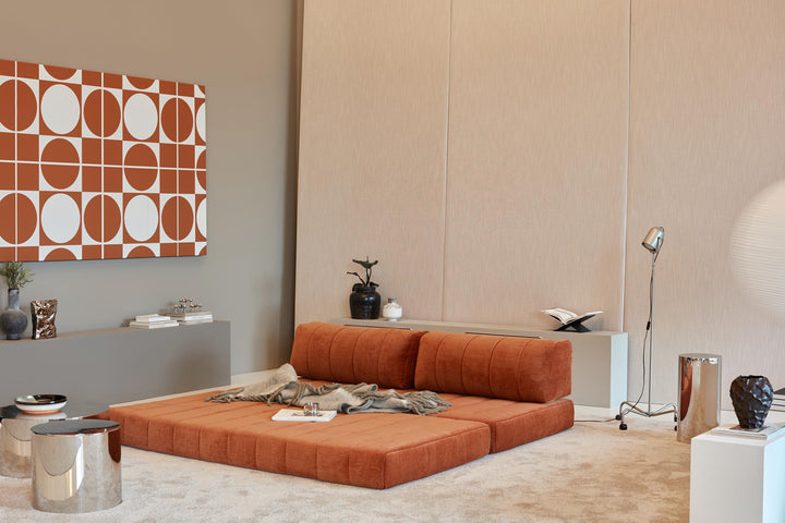 CozyPad Sleeper Sofa by Innovation Living in rust orange velvet laid flat as a lounge with magazines beneath a geometric wall print