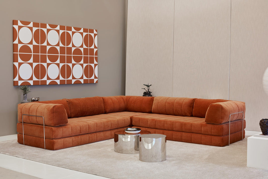 CozyPad Sleeper Sofa Corner with arms by Innovation Living in rust orange velvet as a corner sofa with chrome side tables beneath a geometric wall print