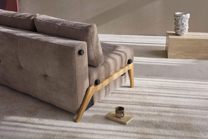 Cubed Sleeper Sofa with Wood Legs by Innovation Living seat cushion with oak wood leg detail on a grey rug