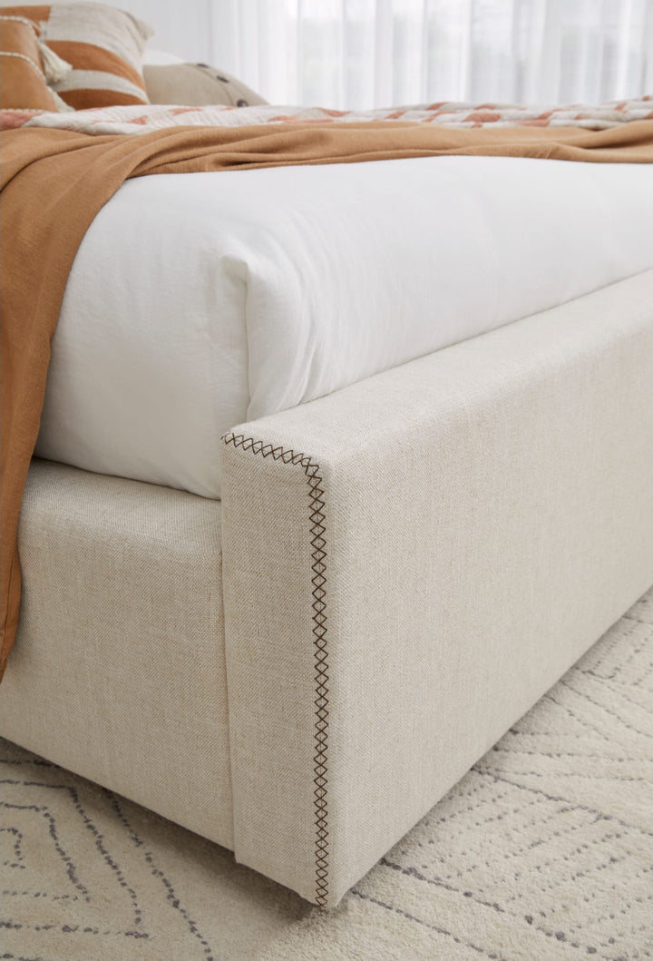 Louis Upholstered Platform Bed in Natural Linen — close-up of the upholstered frame corner
