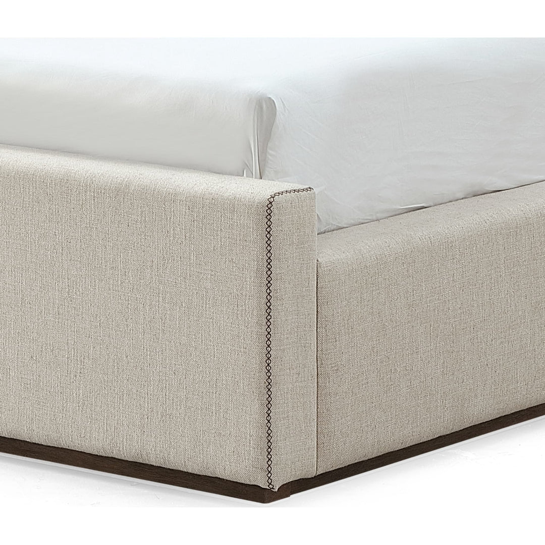 Louis Upholstered Platform Bed in Natural Linen — close-up of the cross-stitch detail at the foot