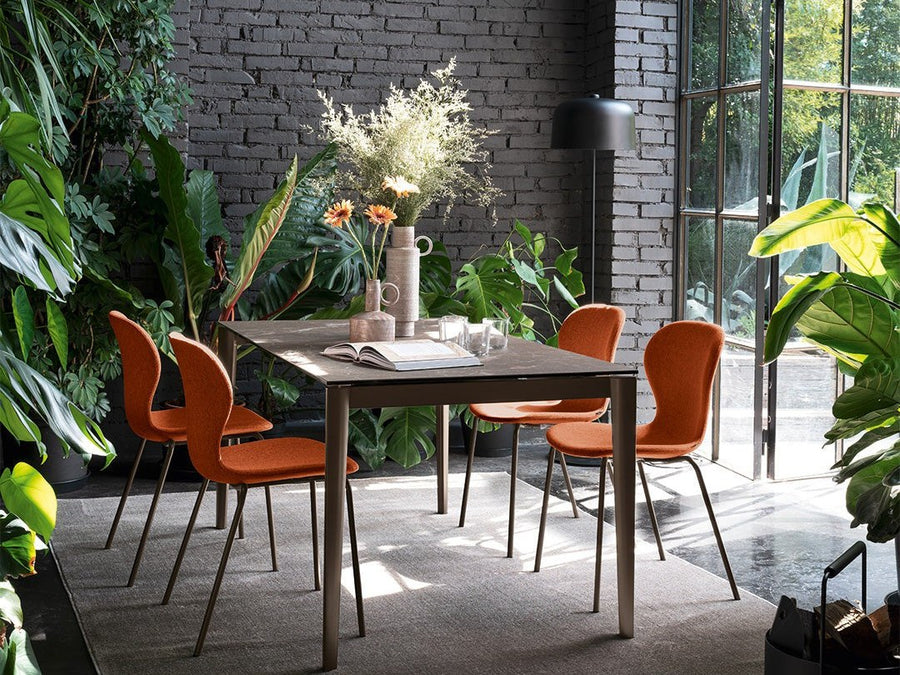 Connubia Artic extendable dining table with orange dining chairs