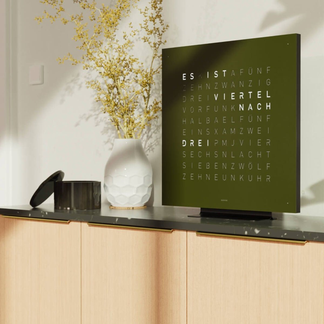 QLOCKTWO EARTH 45 Olive word clock above a wood sideboard