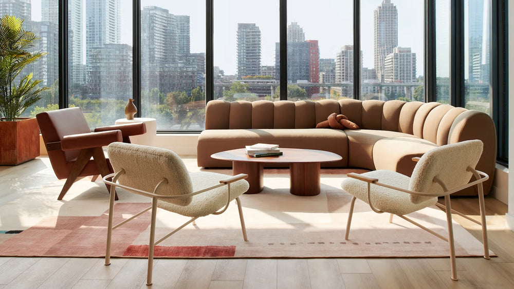Coffee table surrounded by lounge seating in a sunlit city apartment