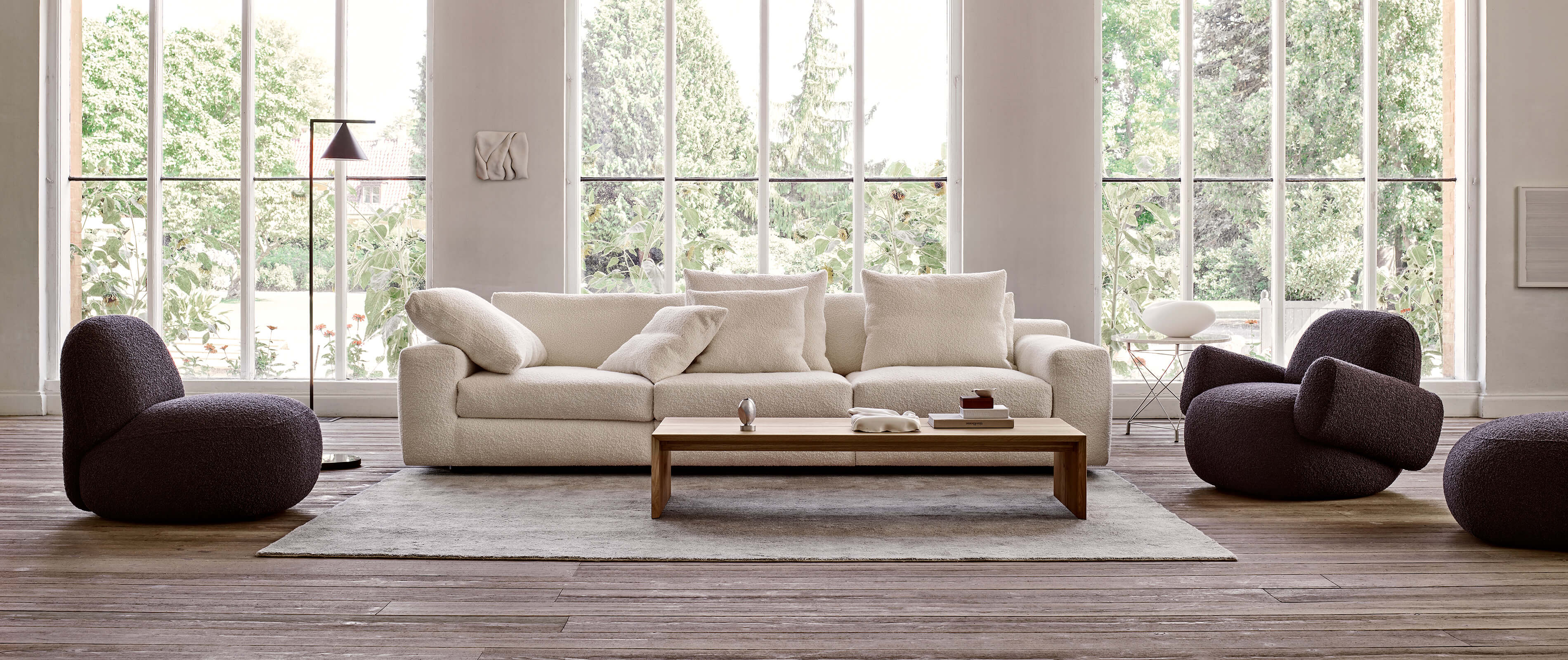 Aton sectional sofa with Havana chairs in a garden-view room