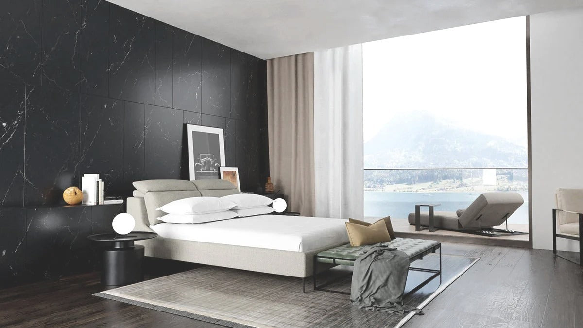 Lake house bedroom with upholstered platform bed, green bench, and black pedestal side tables