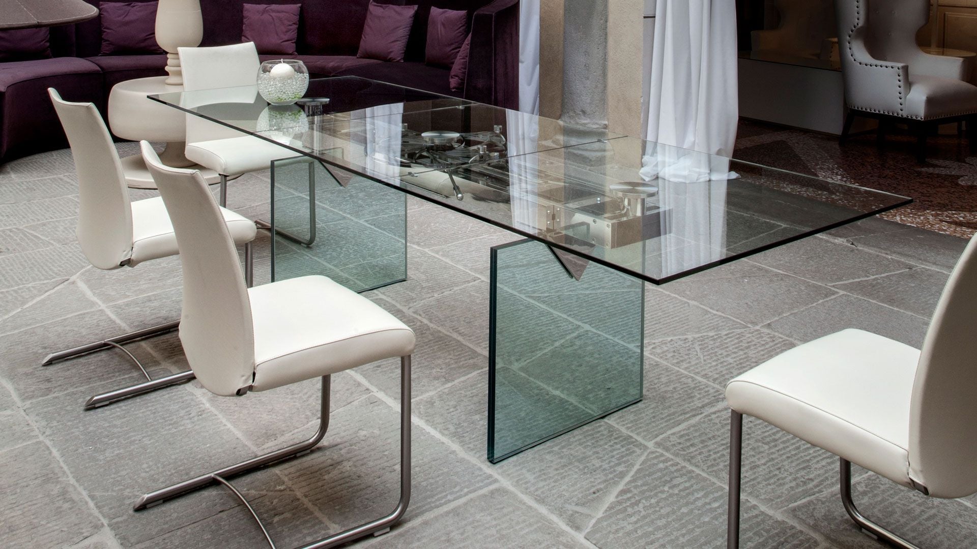 NAOS Quasar glass dining table with white sled chairs