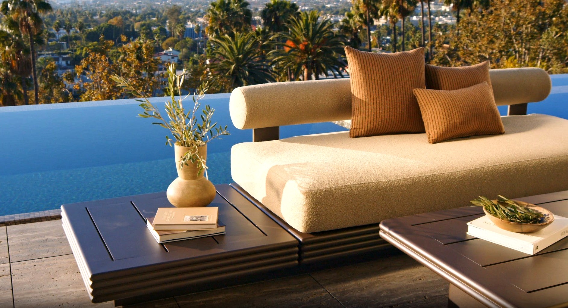 Collins aluminum daybed on a pool terrace at golden hour