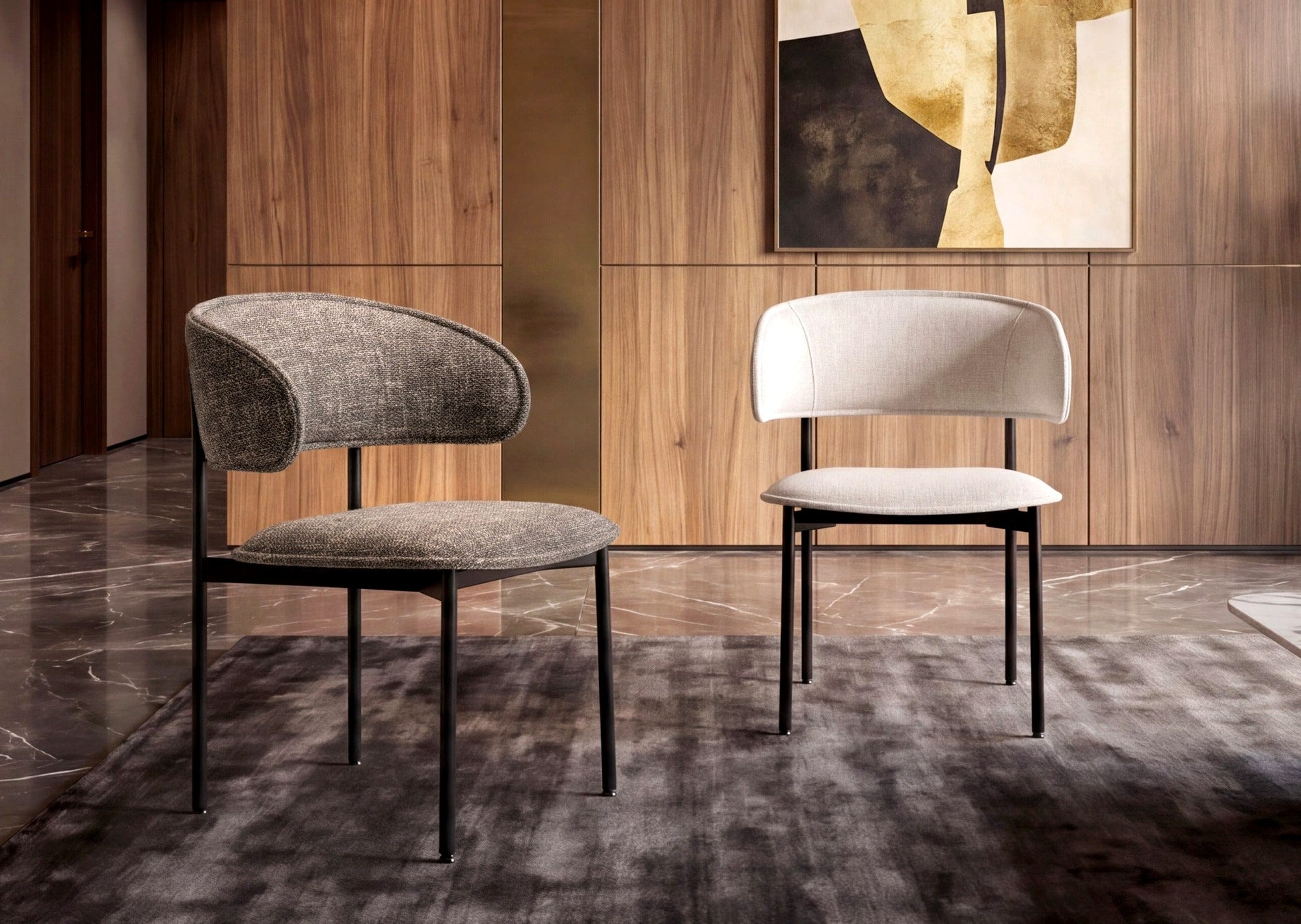 Two Trica Chloé dining chairs against wood paneling